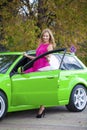 Portrait of a beautiful blonde woman and green sports car Royalty Free Stock Photo