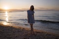 Standing full height: Portrait of a Beautiful blonde woman in a light blue dress on the Baltic Sea beach during sunset Royalty Free Stock Photo