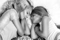 Portrait of the beautiful blonde woman mother and daughter on the beautiful face and amazing eyes lie sleeping on a bed in an eleg Royalty Free Stock Photo