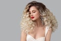 Portrait of a beautiful blonde woman with red lipstick on her lips. Curly blond long hair. Hairstyle Royalty Free Stock Photo