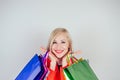 Portrait of beautiful blonde woman shopaholic in a red coat with shopping bags . concept of shopaholism and sales