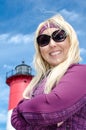 Portrait of a beautiful blonde woman, smiling with her arms crossed in front of Nauset Lighthouse on Cape Cod Royalty Free Stock Photo