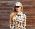 Portrait of beautiful blonde woman wearing a leopard dress and sunglasses Royalty Free Stock Photo