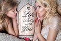Portrait of the beautiful blonde woman mother and daughter on the beautiful face and amazing eyes lie sleeping on a bed in an eleg Royalty Free Stock Photo