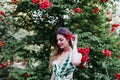 Portrait of beautiful blonde young woman smiling at sunset. Playing with red flowers. Happiness and lifestyle concept outdoors Royalty Free Stock Photo