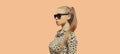 Portrait of beautiful blonde young woman wearing leopard dress and sunglasses on background Royalty Free Stock Photo