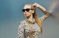 Portrait beautiful blonde young woman wearing a leopard dress and sunglasses in the city Royalty Free Stock Photo