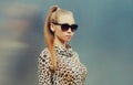 Portrait beautiful blonde young woman wearing a leopard dress and sunglasses in the city Royalty Free Stock Photo