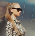 Portrait beautiful blonde young woman wearing a leopard dress and sunglasses in the city Royalty Free Stock Photo
