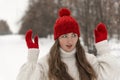 Portrait of beautiful blue-eyed girl in knitted red hat and mittens and woolen sweater in winter park. Ladies knitwear Royalty Free Stock Photo