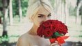 Portrait of a beautiful bride with a bouquet of red roses in her hands. Royalty Free Stock Photo