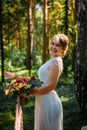 Portrait of a beautiful bride among green trees on sunny summer day. Young girl in a white wedding dress Royalty Free Stock Photo