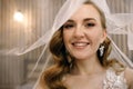 Portrait of a beautiful bride with stylish makeup and white veil