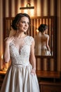 Portrait of a beautiful bride in a wedding dress near a mirror