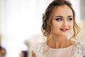 Portrait of beautiful bride in white wedding dress standing in boudoir room and smiling Royalty Free Stock Photo