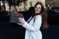 Portrait of beautiful brunette girl with black gift box in her hands. Happy stylish girl holds box with red bow Royalty Free Stock Photo