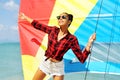 Portrait of beautiful brunette girl holds boat sails and smiling