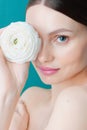 Portrait of a beautiful brunette girl with a white rose on a blue background