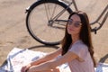 Portrait of beautiful brunette with her bike at the seaside