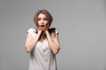 Portrait of beautiful brunette woman with a astonished expression posing in studio on gray background Royalty Free Stock Photo