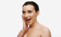 Portrait of beautiful, brunette woman with bare shoulders and perfect smooth skin looking away with surprised face over Royalty Free Stock Photo