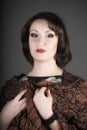 Portrait of a beautiful brunette woman with a brown scarf with a pattern on her shoulders in a studio