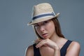 Portrait of beautiful young woman in a fashionable hat is posing isolated on gray background in a studio close up, casual style Royalty Free Stock Photo