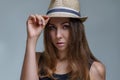 Portrait of beautiful brunette woman in a fashionable hat is stylish posing on gray background in a studio close up Royalty Free Stock Photo