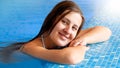 Portrait of beautiful brunette woman with long hair relaxing in swimming pool Royalty Free Stock Photo