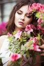 Portrait of a beautiful brunette woman in pink dress and colorful make up outdoors in azalea garden Royalty Free Stock Photo