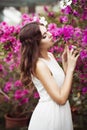 Portrait of a beautiful brunette woman in pink dress and colorful make up outdoors in azalea garden Royalty Free Stock Photo