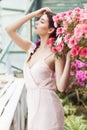 Portrait of a beautiful brunette woman in pink dress and colorful make up outdoors in azalea garden Royalty Free Stock Photo