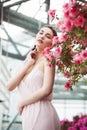 Portrait of a beautiful brunette woman in pink dress and colorful make up outdoors in azalea garden Royalty Free Stock Photo