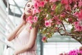 Portrait of a beautiful brunette woman in pink dress and colorful make up outdoors in azalea garden Royalty Free Stock Photo