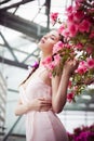 Portrait of a beautiful brunette woman in pink dress and colorful make up outdoors in azalea garden Royalty Free Stock Photo