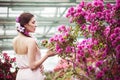 Portrait of a beautiful brunette woman in pink dress and colorful make up outdoors in azalea garden