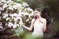 Portrait of a beautiful brunette woman in pink dress and colorful make up outdoors in azalea garden Royalty Free Stock Photo