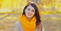 Portrait of beautiful brunette woman wearing scarf in autumn