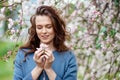 Portrait of a beautiful brunette women in blue jacket  in blossom apple tree garden in spring time. Enjoy Nature. Healthy smiling Royalty Free Stock Photo