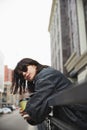 Portrait of beautiful brunette young woman in sunglasses and trendy casual grey jacket walking around city, posing Royalty Free Stock Photo