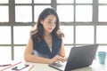Portrait of beautiful business Asian woman sitting at her desk working on laptop computer in modern office. Smiling Successful Royalty Free Stock Photo