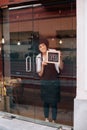 Cafe owner putting an open sign on the glass door Royalty Free Stock Photo