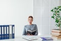 Portrait of a beautiful business woman at a table with books at work in the office Royalty Free Stock Photo