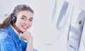 Portrait of beautiful business woman working at her desk with headset and laptop Royalty Free Stock Photo