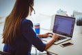 Portrait of beautiful business woman working at her desk with headset and laptop Royalty Free Stock Photo