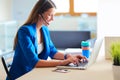 Portrait of beautiful business woman working at her desk with headset and laptop. Royalty Free Stock Photo