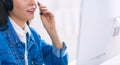 Portrait of beautiful business woman working at her desk with headset and laptop Royalty Free Stock Photo