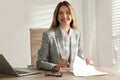 Portrait of beautiful young businesswoman with laptop at table in office Royalty Free Stock Photo