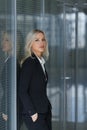 Portrait of beautiful businesswoman leaning against wall in office. Royalty Free Stock Photo