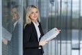 Portrait of beautiful businesswoman smiling and standing with folder in the office Royalty Free Stock Photo